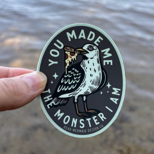 Sticker with a design of a bird and text held by a hand against a textured background